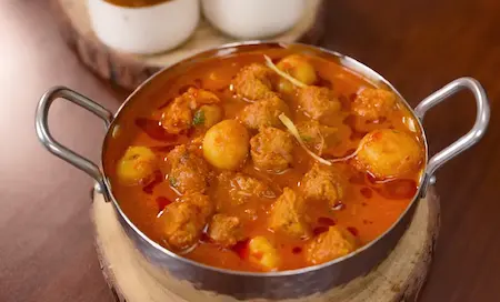 Soya Dum Aloo garnished with fresh coriander and ginger julienne, ready to be served.