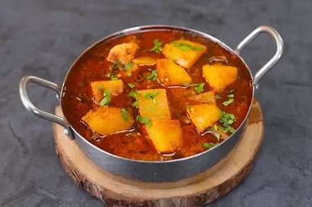 Garnished Spicy Aloo Sabji served with rice and roti