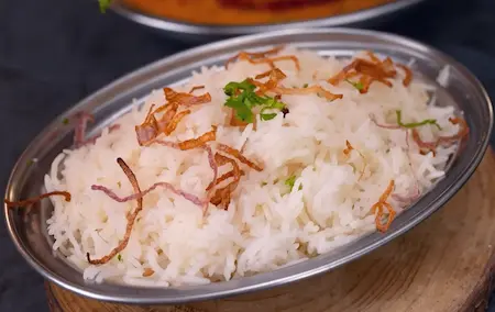 Serving ghee pulao in a bowl