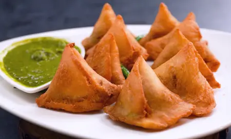 Serving crispy bread samosas with mint chutney and tamarind sauce