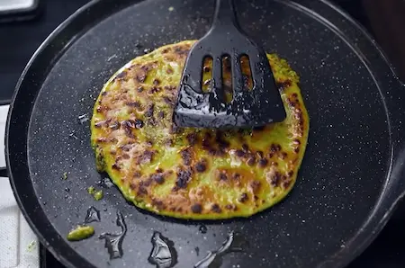 Cooking Matar aur Bathua Paratha on tawa