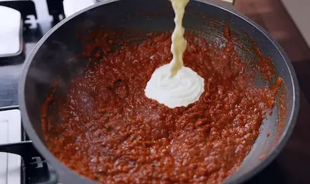 Adding curd to gravy for Lababdar Dhaba Style Egg Masala Recipe