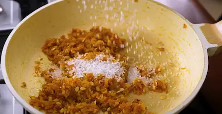 Mixing sugar into the cooked pumpkin for Kaddu Ka Halwa.