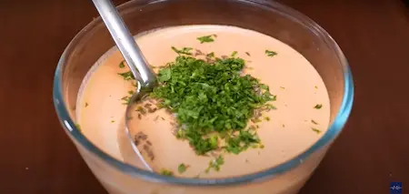 Adding jeera, salt, and chopped coriander to the dosa batter.