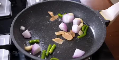 Sautéing green chili, garlic, ginger, and onion for the chutney preparation.