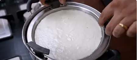 Steaming the dhokla in a mold.