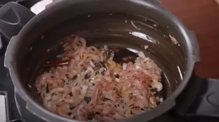 Sautéing onions until golden brown for Veg Pulao.