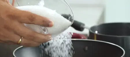 Preparing the jalebi batter by mixing flour, besan, curd, and water to a smooth consistency.