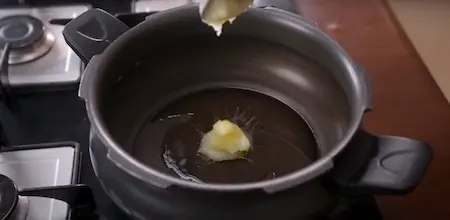 Heating oil and ghee in a pressure cooker for Veg Pulao.