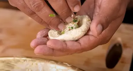 Shaping and stuffing the kebabs with the prepared nutty mixture.