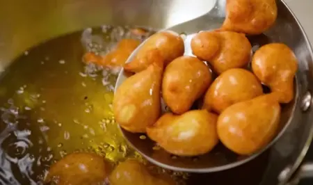 Golden brown vadas frying in hot oil.