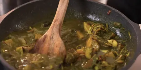 Jackfruit pieces boiling in a pot with spices and water.