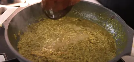 Jackfruit Donne Biryani being cooked in a large pan with rich, aromatic spices.