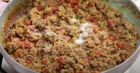  A close-up shot of the keema filling being cooked in the pan with spices.