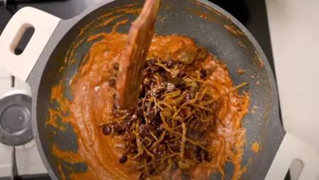 Soaked Panchkuta mix being added to the pan and simmered.