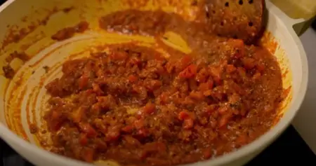 Chopped tomatoes being added to the mixture and cooked for 2-3 minutes.