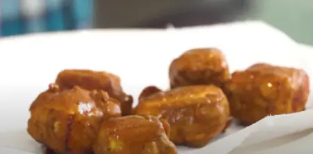 Paneer cubes being deep-fried until they are crispy and golden brown, ready to be added to the gravy.