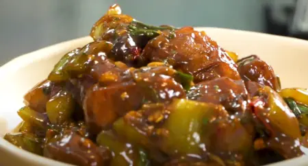 Paneer Manchurian garnished with chopped spring onion and coriander, ready to be served hot.