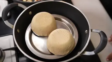 Preparing crispy wheat flour katori shells for the Katori Chaat by draping dough over steel bowls and cooking in a pan.