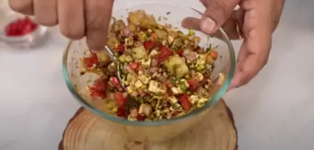  Mixing the chaat filling with sprouts, paneer, and spices for the Katori Chaat.