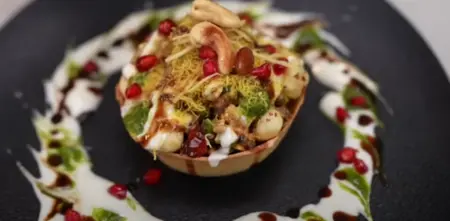 Assembling the Katori Chaat with curd, chutneys, and a mix of chaat filling in wheat flour katori.