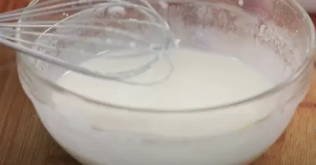 Diced paneer being coated with cornflour in preparation for frying.