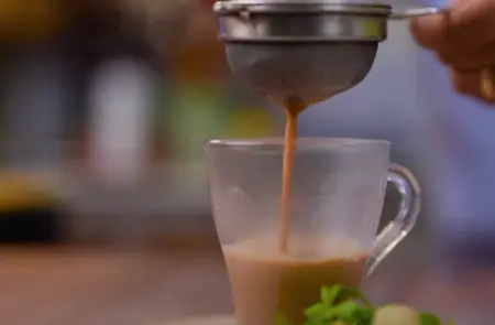 Pudina Wali Chai infused with fresh mint leaves, served hot in a cup.