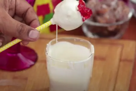 Dipping cake pops in smooth white chocolate sauce.