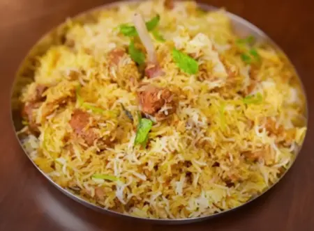 Mutton Biryani served hot with Burani Raita.