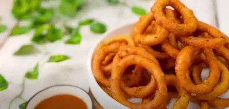 Golden brown crispy potato rings served hot on a plate, ready to enjoy.