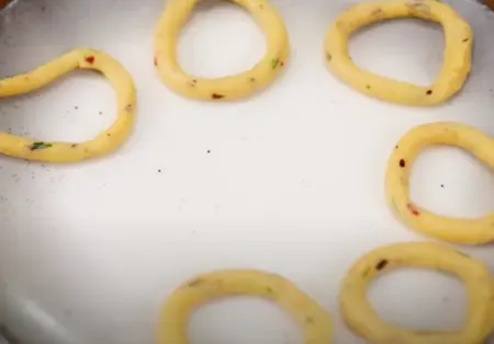 Corn starch and chopped coriander mixed into the cooled potato mixture, shaped into rings.