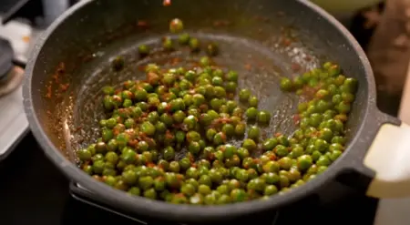 Cooking the puri stuffing with green peas and spices.