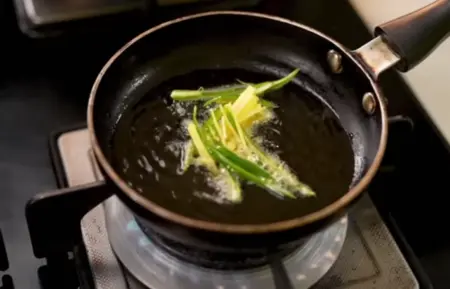 Preparing the tadka with ginger and green chilies.