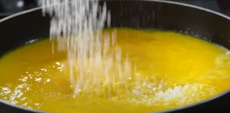 adding sugar in the mango  mixture