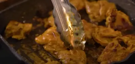 Sliced cooked chicken in a pan, ready for stuffing.