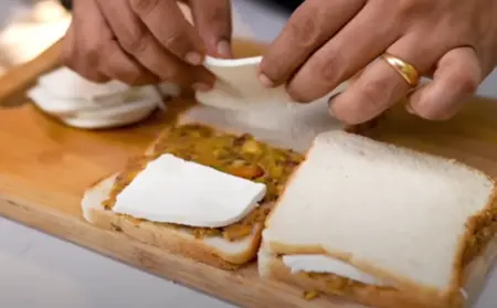 Assembling bread pakodas with stuffing and paneer slices.