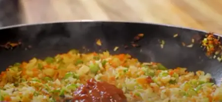 Cooking vegetable stuffing with garlic, ginger, onion, and mixed vegetables for momos.