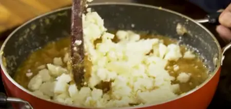  Cardamom powder and mawa being mixed into the halwa.