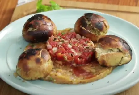 Litti Chokha served with chutney on a decorative plate.