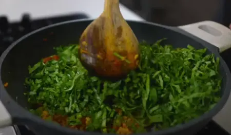 Radish leaves and moong dal being cooked together