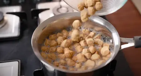 Soy chunks being soaked in hot water in a bowl, softening for the recipe.