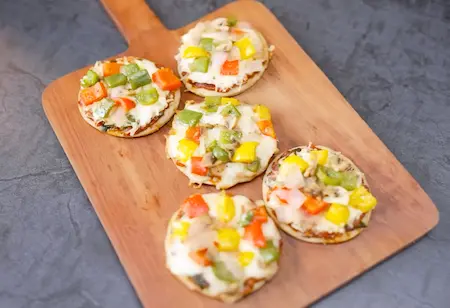 Serving freshly made mini tawa pizzas on a plate.