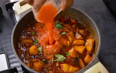 Adding tomato puree and finishing touches to Spicy Aloo Sabji