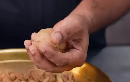 Shaping Pinni Laddus with hands to form round sweet balls