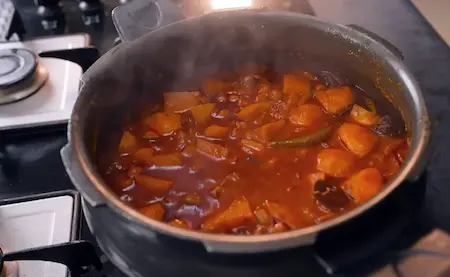 Simmering aloo chana sabzi with garnished coriander leaves