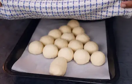 Proofing buns covered with a damp cloth