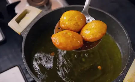 Frying Dhuska in oil to make it crispy