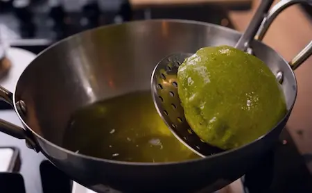 Palak puris being fried in oil