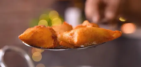 Deep frying bread samosas until golden and crispy