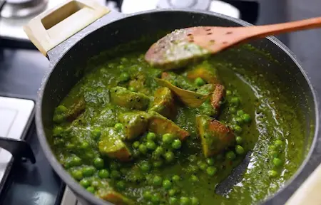 Adding green paste to the dish